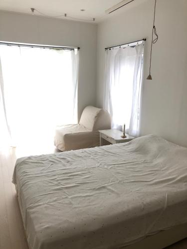 a bedroom with a white bed and a window at Maison de Clare in Gyeongju