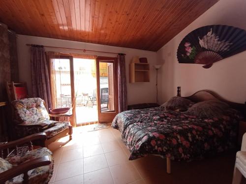 a bedroom with a bed and a chair at Tranquil and Spacious Townhouse in Historical and Picturesque Cervera Del Maestre in Cervera del Maestre