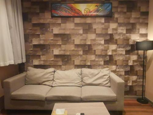 a living room with a couch in front of a brick wall at Shanghai Fish Inn Bund in Shanghai