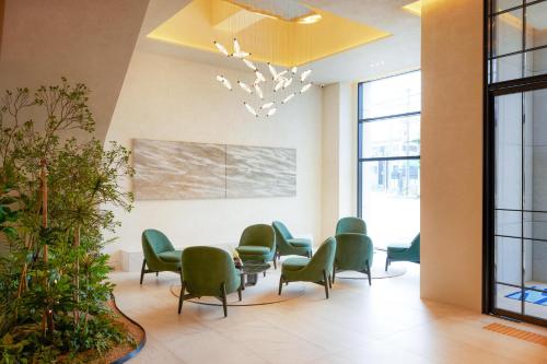 a waiting room with green chairs and a table at Homm Marina Sokcho in Sokcho