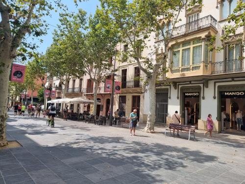 a street in a city with people walking on the sidewalk at Piso céntrico a estrenar in Vilanova i la Geltrú