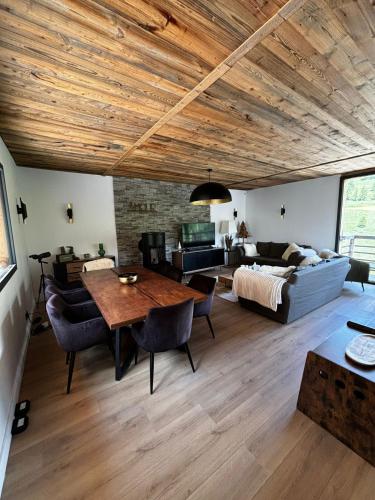 a living room with a table and a couch at Un Écrin de Sérénité Face aux Montagne chalet nathalya in Vars