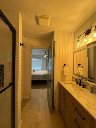 a bathroom with a sink and a mirror and a bedroom at Boho Island Paradise Remodel 2BR in Waikoloa Village