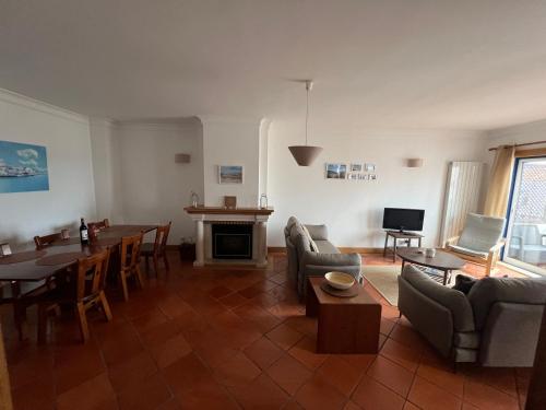 a living room with a table and chairs and a fireplace at Casa S & S in São Martinho do Porto