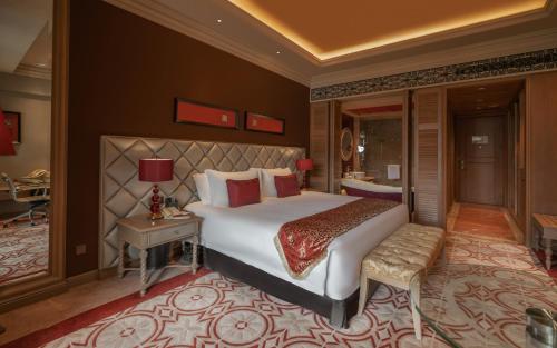 a bedroom with a large bed and a desk and a bed sidx sidx at Jinjiang International Hotel Ganzhou in Ganzhou