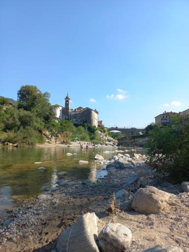 a river with rocks and buildings in the background at Apartmaji Tinta in Kanal