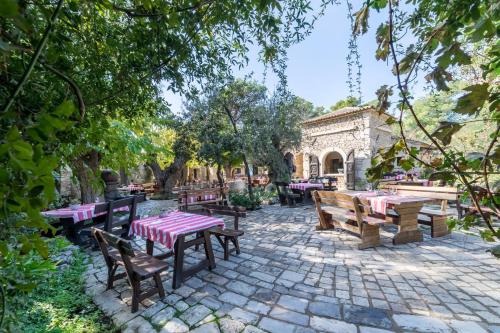 a patio with picnic tables and benches in a park at Amadria Park Camping Sibenik Mobile Homes in Šibenik