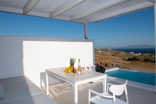 a white dining room with a white table and chairs at The Ammonite Resort in Super Paradise Beach