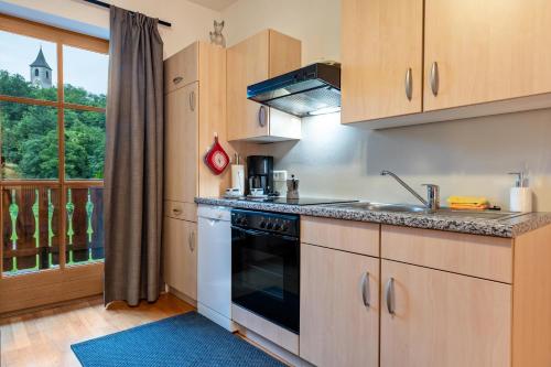 a kitchen with a stove top oven next to a window at Apt Morgensonne Zunerhof in Campodazzo