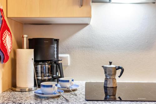 a counter top with two cups and a coffee maker at Apt Morgensonne Zunerhof in Campodazzo