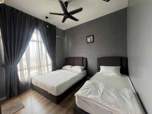 a bedroom with two beds and a ceiling fan at The Majestic Imperial Tower Premium Suite - Ipoh in Ipoh