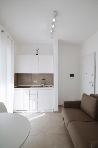 a living room with a couch and a kitchen at Gioema in Borgo Vodice