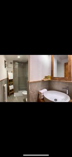 a bathroom with a sink and a tub and a toilet at Hotel Coeur Du Village in La Thuile