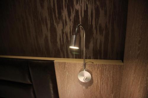 a light hanging from a wall with a wooden wall at Shanghai Fish Inn Bund in Shanghai