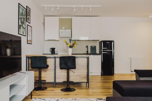 a kitchen with a counter and two bar stools at Dom Goscinny Bialy Dworek in Człuch&oacute;w