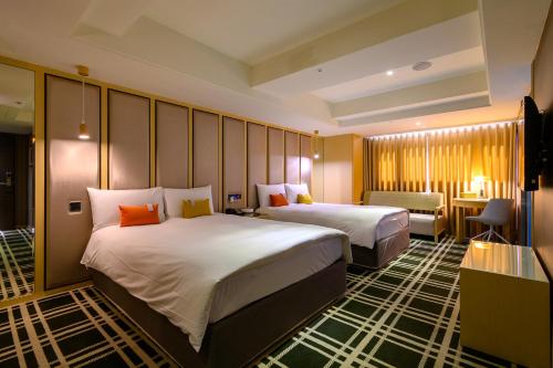 a hotel room with two beds and a desk at Olah Poshtel Taichung Wenxin in Taichung