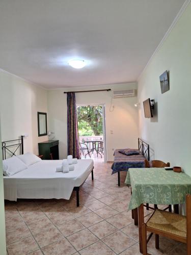 a bedroom with a bed and a table and a balcony at Villasabella in Laganas