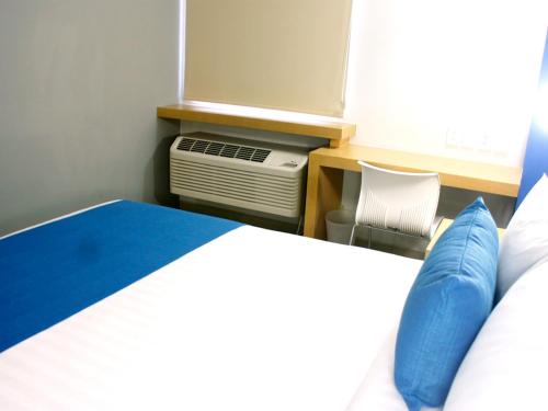a bedroom with a bed and an air conditioner at Hotel Urbainn in Veracruz
