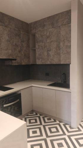 a kitchen with white cabinets and a sink at The Bliss Studio's in Ghaziabad