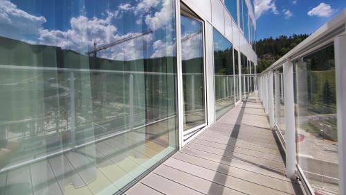 an empty balcony of an office building with glass windows at Aparthotel Biała Perła - Czarna Góra Resort, Sun & Snow in Sienna