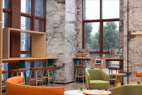 a restaurant with colorful chairs and tables and windows at Home2 Suite by Hilton Changsha Ningxiang in Ningxiang