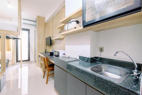 a kitchen with a sink and a counter at Minimalist and Good Deal Studio Transpark Cibubur Apartment By Travelio in Depok