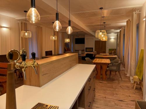 a kitchen with pendant lights and a living room at Tkalcovna U Zlatého potoka in Dobřany