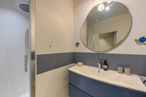 une salle de bain avec un lavabo et un miroir dans l'établissement La Demeure de l'Armateur - Appt vue port de Vannes, à Vannes