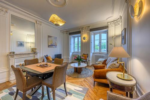 un salon avec une table et des chaises dans l'établissement La Demeure de l'Armateur - Appt vue port de Vannes, à Vannes