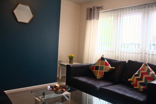 a living room with a couch and a window at The Sawmills, Carlisle - Spacious 4 Bedroom Family House - Free WiFi - & Parking - Walk to Carlisle Castle in Carlisle