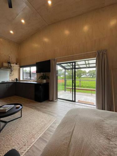 a bedroom with a large bed and a large window at LyeInn - Newstead Country Retreat in Newstead