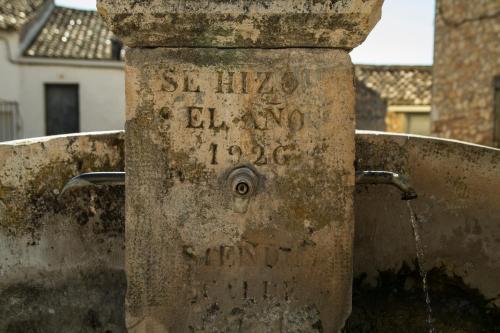 a stone fountain with water coming out of it at El Horno de Leopoldo in Hueva