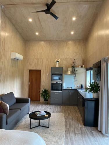 a living room with a couch and a kitchen at LyeInn - Newstead Country Retreat in Newstead