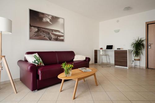 a living room with a purple couch and a table at I Cinque Pini in Follonica
