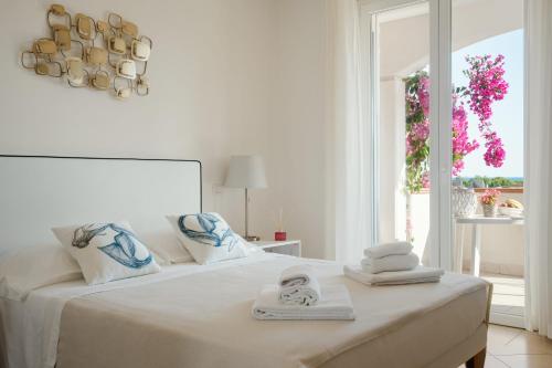 a white bedroom with a bed with towels on it at I Cinque Pini in Follonica