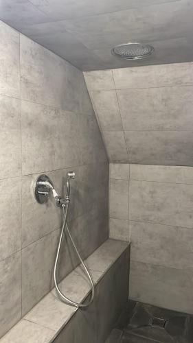 une douche avec un tuyau dans une salle de bain dans l'établissement Charme et tout confort prêt stade de France JO, à Montmagny