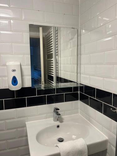 a white bathroom with a sink and a mirror at Hotel Waddengenot in Pieterburen
