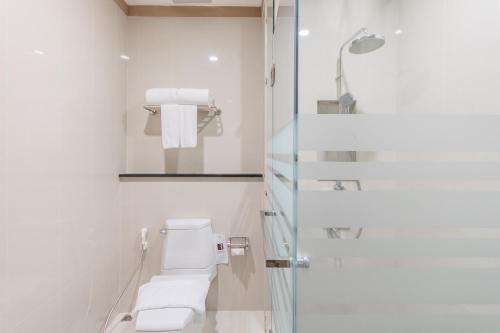 a white bathroom with a toilet and a shower at Hillside Residence Khaoyai in Mu Si