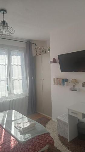 Cette chambre blanche dispose d'une table et d'une fenêtre. dans l'établissement Chambre individuelle pour une personne, à Blois