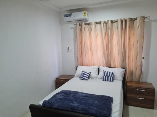 a bedroom with a bed with two pillows on it at D11 New Oak in Accra