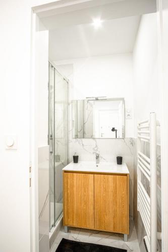 La salle de bains est pourvue d'un lavabo en bois et d'une douche. dans l'établissement Bel Appartement F3 lumineux wi-fi, au Havre
