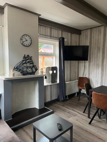 a living room with a fireplace and a clock on the wall at Hotel Waddengenot in Pieterburen