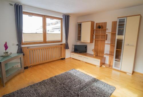 an empty living room with a television and a window at Ferienwohnung Alpenblick in Navis
