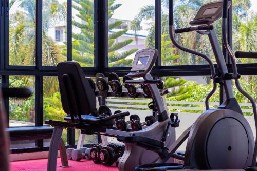 a gym with a bunch of exercise equipment in front of a window at Phavina Hotel Rayong SHA Extra Plus in Rayong