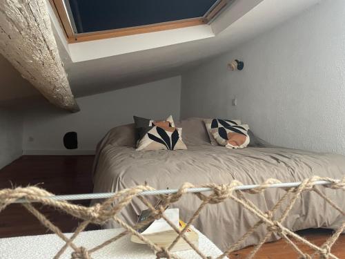 une chambre avec un lit avec des oreillers noirs et blancs dans l'établissement Les Terrasses du Barreau, à Mèze