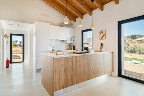 a kitchen with white walls and wooden countertops at Monte Muro Country House in Mourão