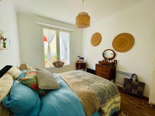 une chambre avec un lit bleu et une fenêtre dans l'établissement Villa Cakine à La Baule, à La Baule