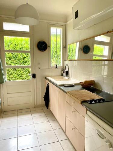 une cuisine blanche avec un évier et une fenêtre dans l'établissement Villa Cakine à La Baule, à La Baule