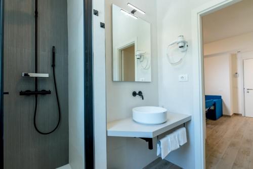a white bathroom with a sink and a shower at Hotel Relax Family & Spa in San Benedetto del Tronto
