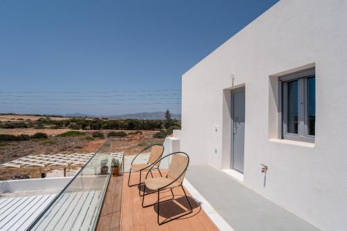 a balcony with three chairs and a view of the ocean at Villa Anastasio in Kampos Paros